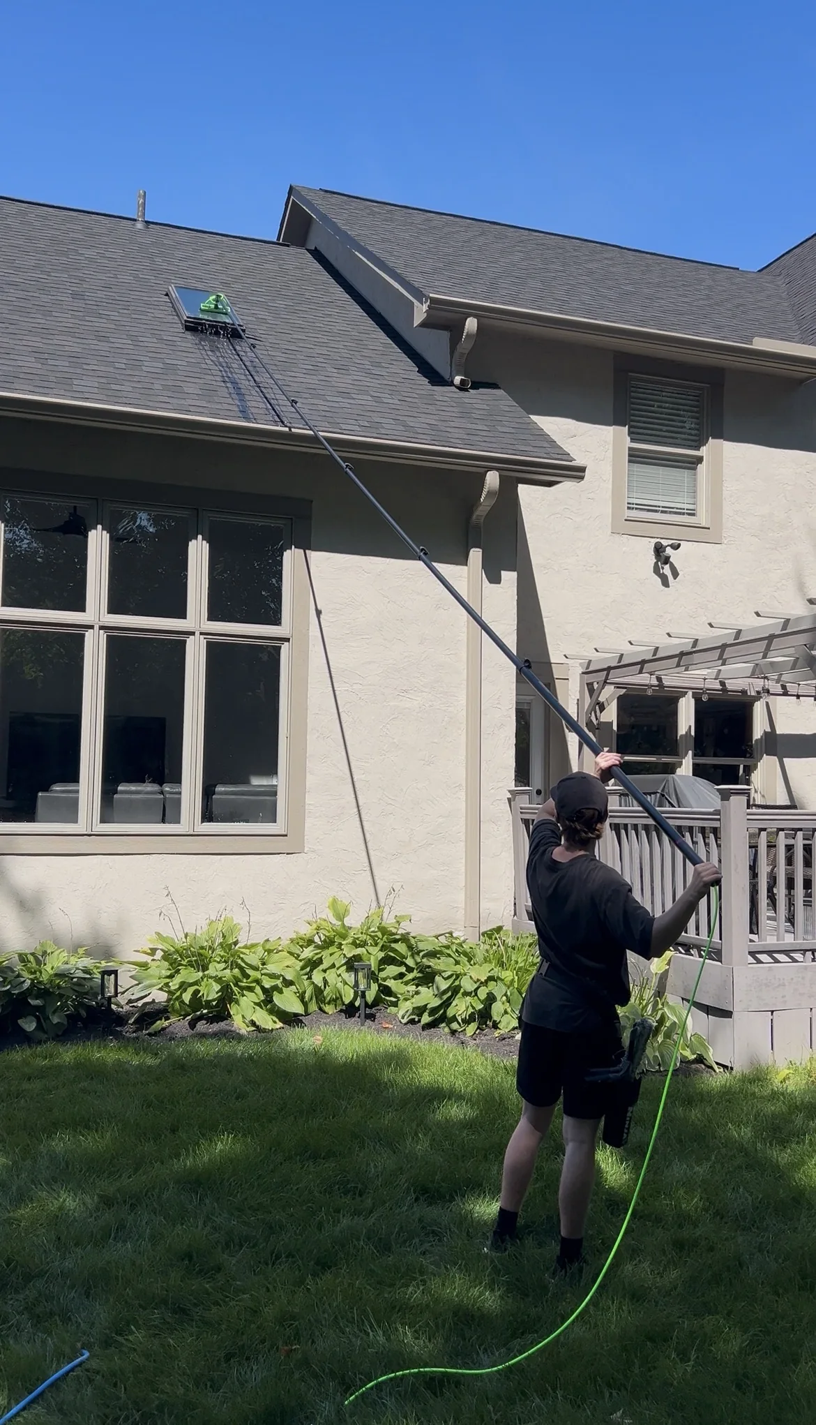 Motion Washing cleaning a high exterior window with a water-fed pole